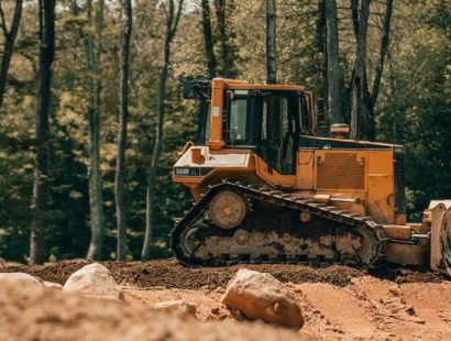 Bodenmaterial wird abgetragen Eine Baumaschine trägt Boden ab